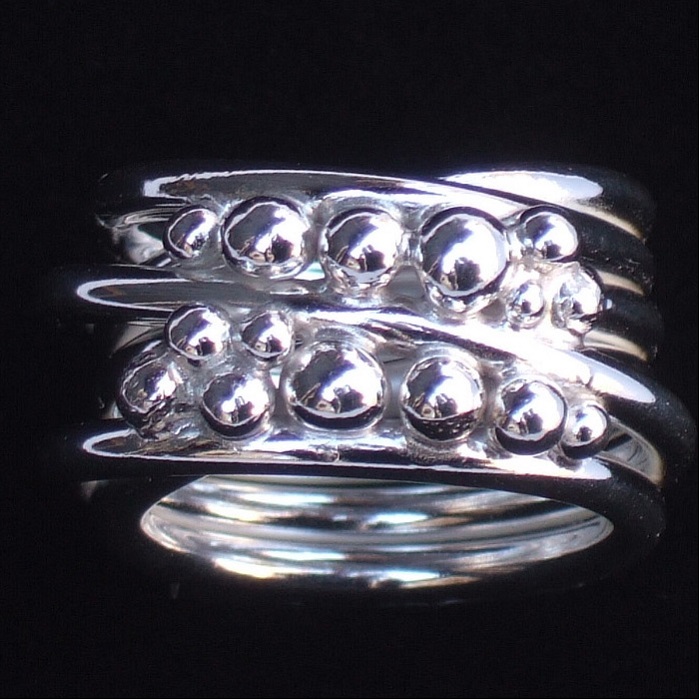 En ring till ditt finger, silvertråd virad i sex varv med kulor på framsidan.